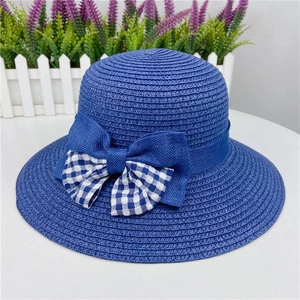 Detail of blue straw sun hat featuring a classic bow and blue-white plaid fabric accent