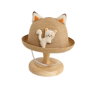 Children's straw sun hat with cute cat ears and embroidery on a wooden stand