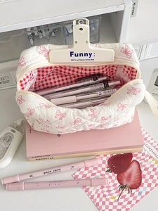Detailed interior of quilted cotton pouch with pink bow print and red checkered lining