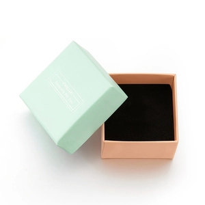 Detail of mint green and pink square jewelry box with black sponge lining insert