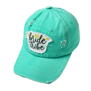 Detail of mint green distressed baseball cap with bride tribe embroidered patch