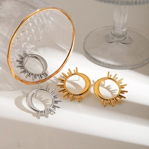 Detailed view of gold and silver sun and moon stud earrings on a clean white surface