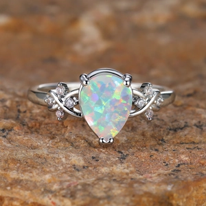 Elegant pear cut opal ring with sparkling round diamonds on silver band for women