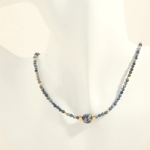 Detail of irregular blue sodalite beads necklace with gold accents on a model bust