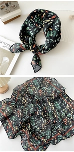 Detail of floral cotton linen neck scarf with green leaf patterns on black fabric