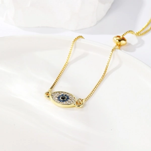 Detail of adjustable evil eye bracelet with blue rhinestones and gold box chain link