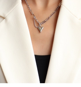 Detail of silver heart pendant necklace with unique mixed chain links on model