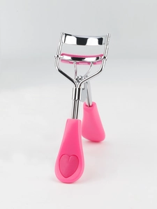 Detailed side view of silver metal eyelash curler with cute pink heart handle grips