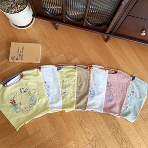 Détails de broderies florales et papillons colorés sur divers sacs à main en tissu Oxford