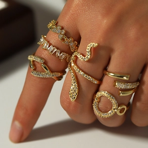 Vue macro d'un ensemble de bagues empilables dorées avec motifs papillon et serpent en zircon