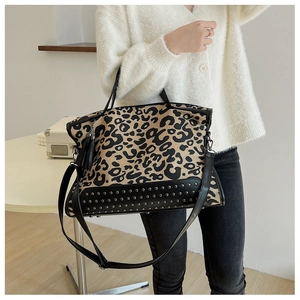 Detail of leopard print tote bag with silver studs and detachable tassel charm