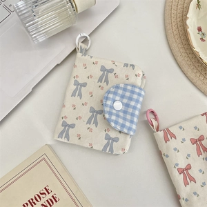 Floral canvas coin purse with blue gingham flap and hook detail on office desk