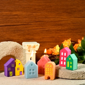 Detailed view of colorful miniature house candles with intricate hollow window designs