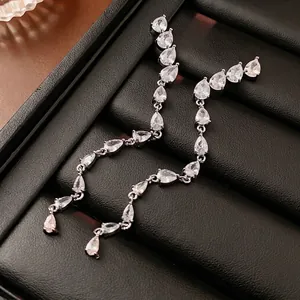 Silver needle drop zircon tassel earrings with pear-shaped stones on black leather