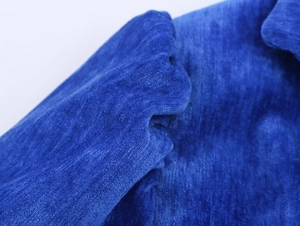 Dettaglio della trama del tessuto ciniglia blu reale e cuciture fini dell'abito