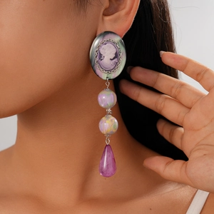 Detail of vintage cameo resin drop earrings with purple beads and iridescent finish
