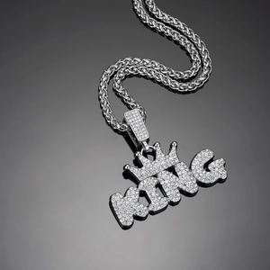 Close-up of iced out silver KING crown pendant with shimmering zircon on wheat chain