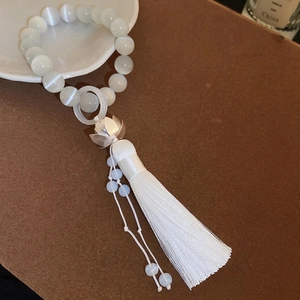 Elegant cat's eye stone lotus flower bracelet with long silk tassels and silver charms