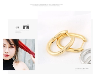 Close-up of minimalist gold and silver oval hoop earrings with polished U-shaped design