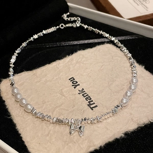 Detailed close-up of bow pendant with mixed silver beads and elegant pearls necklace