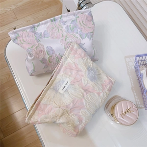 Detailed view of pink rose jacquard fabric and simple wish woven label on makeup bag