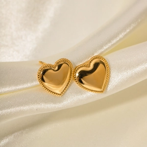 Detail of 18K gold plated stainless steel heart earrings on soft silk fabric