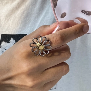 Two-tone stainless steel daisy ring featuring silver petals and golden center