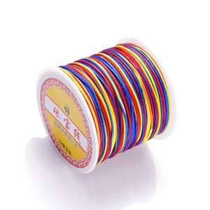 Detailed macro view of multi-color gradient No. 72 jewelry thread on a white spool