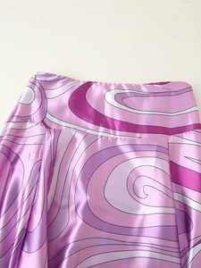 Detailansicht des rosa Satin-Maxirocks mit abstraktem Wirbelmuster an der Taille