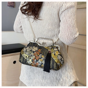 Detail of vintage black brocade shell bag with gold embroidery and pearl strap