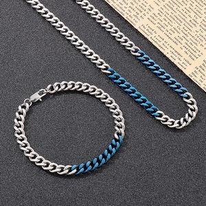 Detailed view of silver and blue two-tone stainless steel Cuban chain necklace and bracelet
