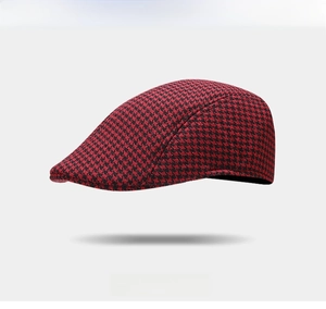 Dettaglio del motivo pied-de-poule rosso e nero su un classico basco retrò alla moda