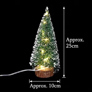 Detail of mini snow-flocked Christmas tree with warm LED lights and a rustic wood base