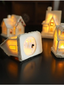 Close-up of the base detail on a light-up resin house showing the LED switch and structure