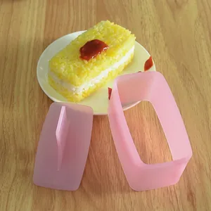 Pink sushi mold set for creating layered rectangular rice balls on a wooden table