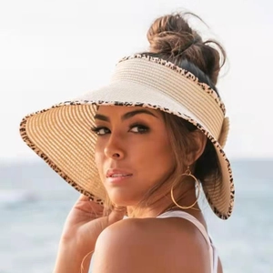 Detail of a straw sun visor with leopard print edge trim for beach vacation style