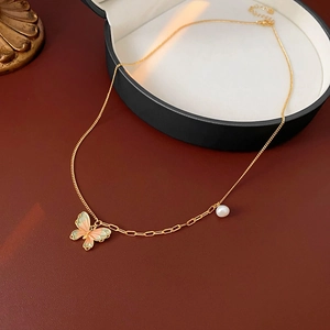 Detail of gold chain necklace with pink and green enamel butterfly and white pearl charm