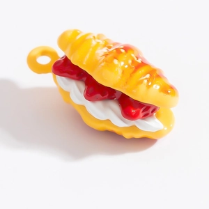 Détail d'un pendentif croissant miniature avec crème blanche et confiture rouge