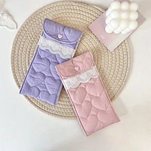 Detail of quilted heart fabric and lace trim on pastel pink and purple sunglass pouches