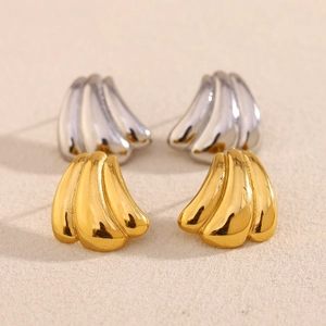 Detailed macro view of gold and silver pumpkin-shaped 18K plated stainless steel stud earrings