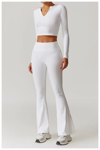 Detail of white high-waist flared yoga pants with split hem and slim-fit crop top shirt