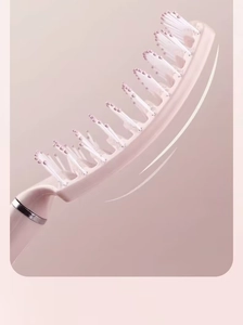 Close-up of pink curved vent brush with round-tipped bristles and silver ring detail