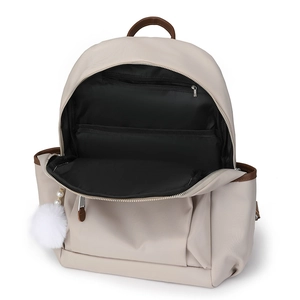 Chic beige nylon backpack with brown trim and fluffy white pompom charm in front view