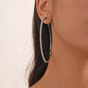 Detail of 8cm oversized silver hoop earrings with sparkling rhinestones on model