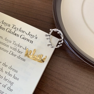 Top view of gold and silver melted drip rings on a wooden desk with a white magazine page