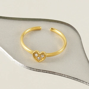 Détail macro de la bague cœur plaquée or 18k avec trois pierres de zircone étincelantes