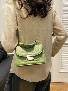 Bolso de mano cuadrado verde acolchado con cadena dorada y asa superior en un modelo