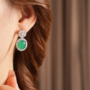 Détail d'une boucle d'oreille vintage argentée avec calcédoine verte et zircons fleuris