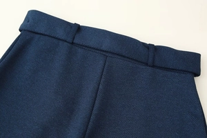 Gros plan d'un pantalon en sergé bleu marine montrant les détails de la taille