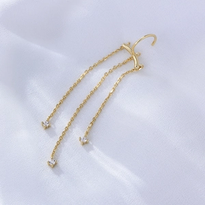 Macro shot of gold tassel drop earrings with sparkling zircon stones and chain fringes